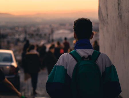 Young man with backpack walking through the Albaicin with sunset.の写真素材