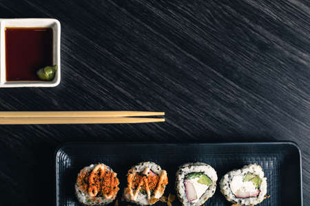Sushi rolls with chopsticks and soy sauce on dark background. Space textの写真素材