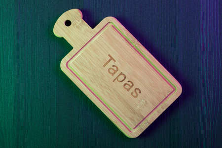 Empty wood plate on wood table background. Spanish Tapa. Copy space and top viewの写真素材