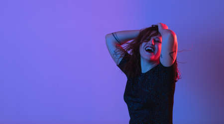 Girl dancing and having fun at party. Colorful light, Studio shot, copyspaceの写真素材