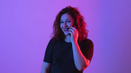 laughing young woman talking on mobile phoneの写真素材