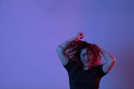 Girl dancing and having fun at party. Colorful light, Studio shot, copyspaceの写真素材