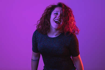 Girl dancing and having fun at party. Colorful light, Studio shot, copyspaceの写真素材