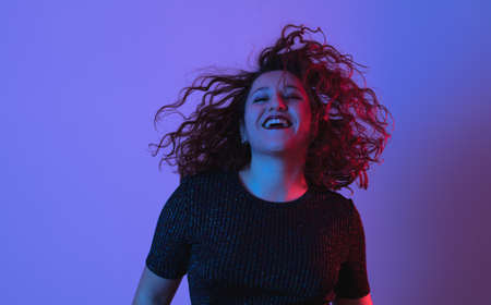 girl posing, studio shot. Face expression and colorful lightの写真素材