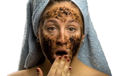 Girl after shower with a towel and different facial expressions, face with homemade coffee creamの写真素材