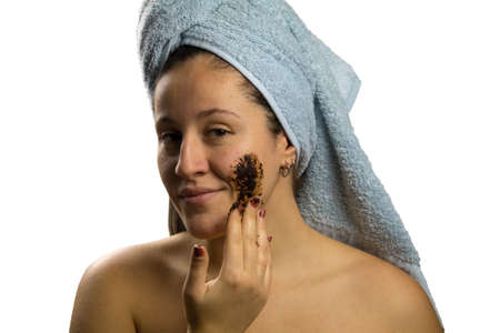 Girl after shower with a towel and different facial expressions, face with homemade coffee creamの写真素材