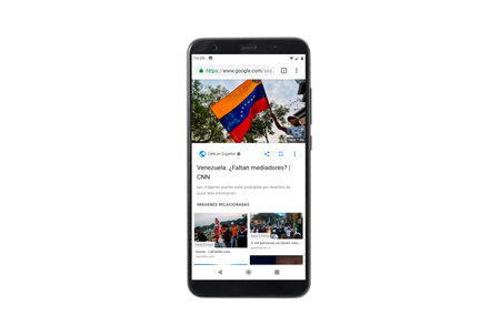 Granada, Spain; February 14, 2019: Venezuela news on mobile screen. Mock up mobile phone isolated on...