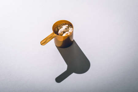 Scoops filled with protein vanilla powders on white background. top view with copy space for text. Sun lightの写真素材