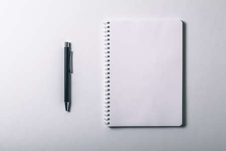 Notebook and pen on white background. Top view and copy space. Blank notebook page for input the text in the middleの写真素材