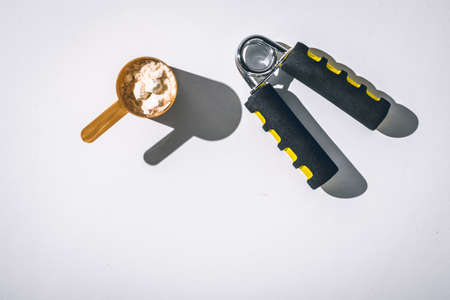 Scoops filled with protein vanilla powders on white background. Top view with copy space for text. Sun lightの写真素材