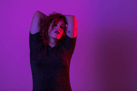 Girl dancing and having fun at party. Colorful light, Studio shot, copyspaceの写真素材