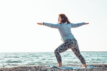 girl doing yoga and stretching on the beach