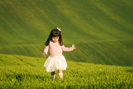 Little girl with pink shirt and skirt in a meadow. Disgusted face. she does not like the field