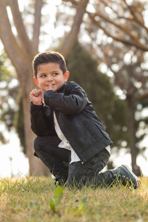 Fashionable child in leather coat. stylish little boy with trendy haircut. Outdoor, at parkの写真素材