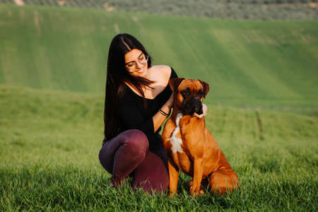 Beautiful woman playing with her dog. Outdoor portrait.の写真素材