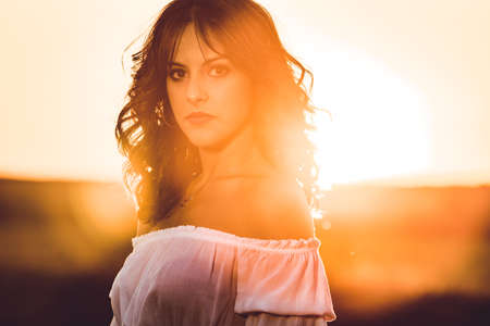 Young brunette woman at sunset. Copy spaceの写真素材