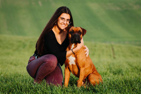 Beautiful woman playing with her dog. Outdoor portrait.の写真素材
