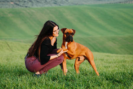 Beautiful woman playing with her dog. Outdoor portrait.の写真素材