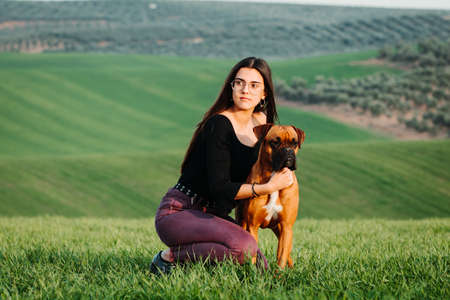 Beautiful woman playing with her dog. Outdoor portrait.の写真素材