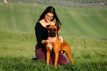 Beautiful woman playing with her dog. Outdoor portrait.の写真素材