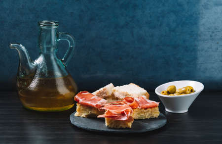delicious Spanish potato omelette top with serrano ham, and olivesの写真素材