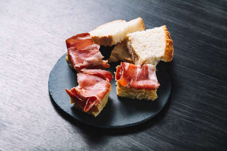 Pincho omelette and ham, with olives. In a restaurantの写真素材