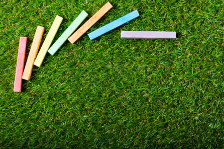Top view of chalks on green plastic grass. Copy spaceの写真素材
