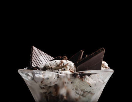 Speciality Italian stracciatella ice cream scoop with flakes of dark chocolate. Isolated on black backgroundの写真素材