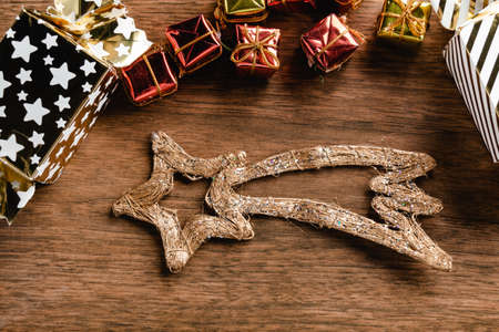 Mini gifts and Christmas shooting star on wood background. Christmas decorationの写真素材
