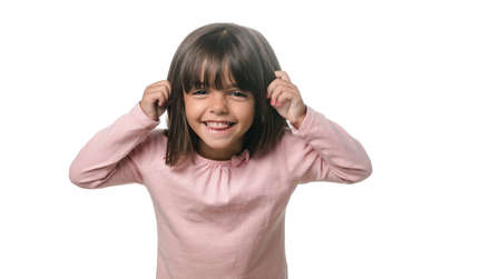 Funny little girl showing the tongue to the camera on white backgroundの写真素材