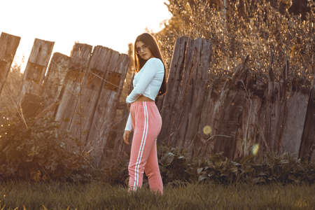 Sunset portrait of beautiful brunette young woman in autumn parkの写真素材