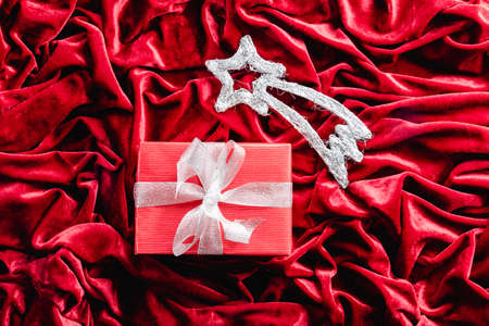 Shooting star and gift on red velvet background. Christmas decorationの写真素材