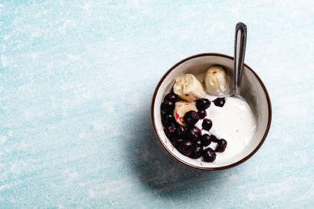 Yogurt with banana, blueberries and chocolate ready to eat in a bowlの写真素材