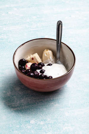 Yogurt with banana, blueberries and chocolate ready to eat in a bowlの写真素材