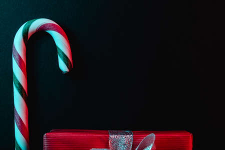 Minimal Christmas composition. Greeting card template with candy cane on dark background.の写真素材