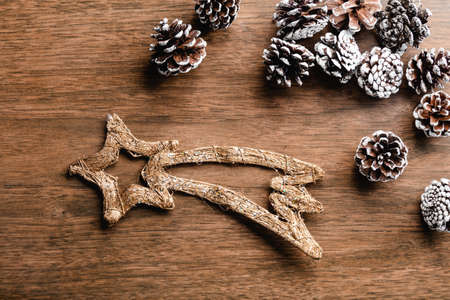 Pine cones and Christmas shooting star on wood background. Christmas decorationの写真素材
