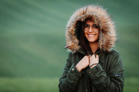 Portrait of a woman feeling cold in winter on green meadowの写真素材