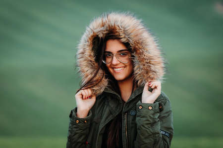 Portrait of a woman feeling cold in winter on green meadowの写真素材