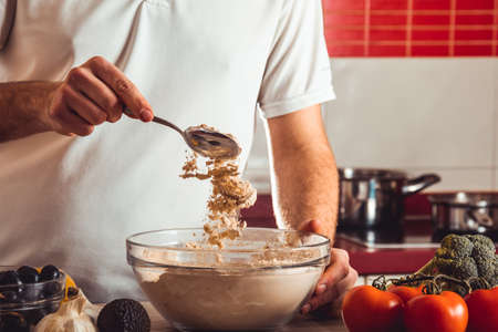 Man doing the seitan cooking process at home. How to prepare seitan at home vegan meatの写真素材