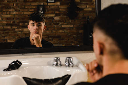 Young Handsome Barber Making Haircut Of teenager Man In Barbershopの写真素材