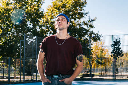 Young cool man break dancer standing in park. Tattoo on bodyの写真素材