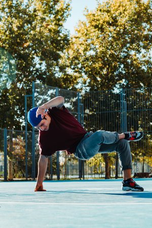 Young b boy dancing and posing at basketball court