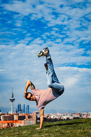 B-boy performing some moves. Breakdancer in modern city background