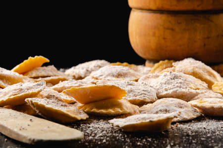 Tasty raw ravioli with flour and basil on wood tableの写真素材