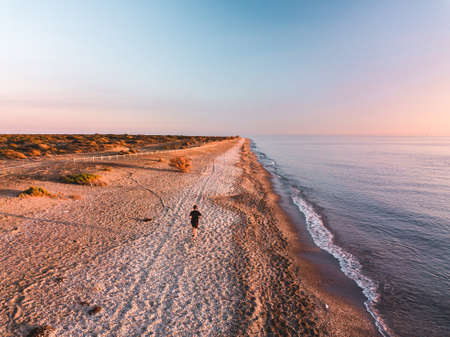 Aerial view one running men on sunsetの写真素材