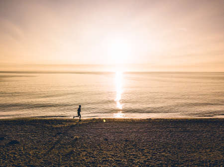 Aerial view one running men on sunsetの写真素材