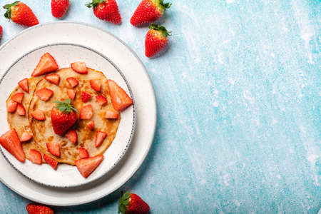 Pancakes with fresh strawberry on a blue wooden backgroundの写真素材
