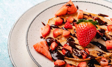 Pancakes with fresh strawberry on a blue wooden backgroundの写真素材