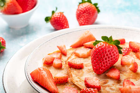 Pancakes with fresh strawberry on a blue wooden backgroundの写真素材