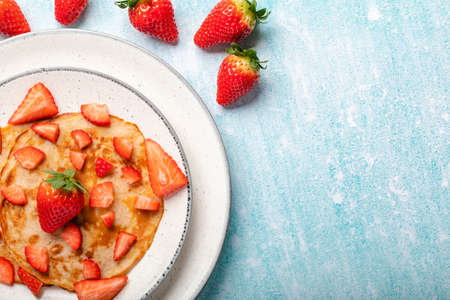 Pancakes with fresh strawberry on a blue wooden backgroundの写真素材